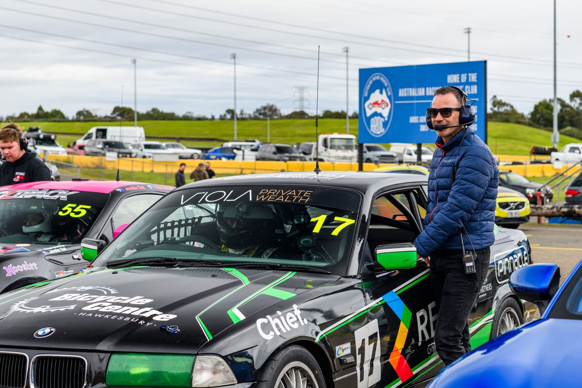 The #17 Project E36 BMW 328i on the grid at Sydney Motorsport Park with a crew member at the driver's window before MRA Round 5