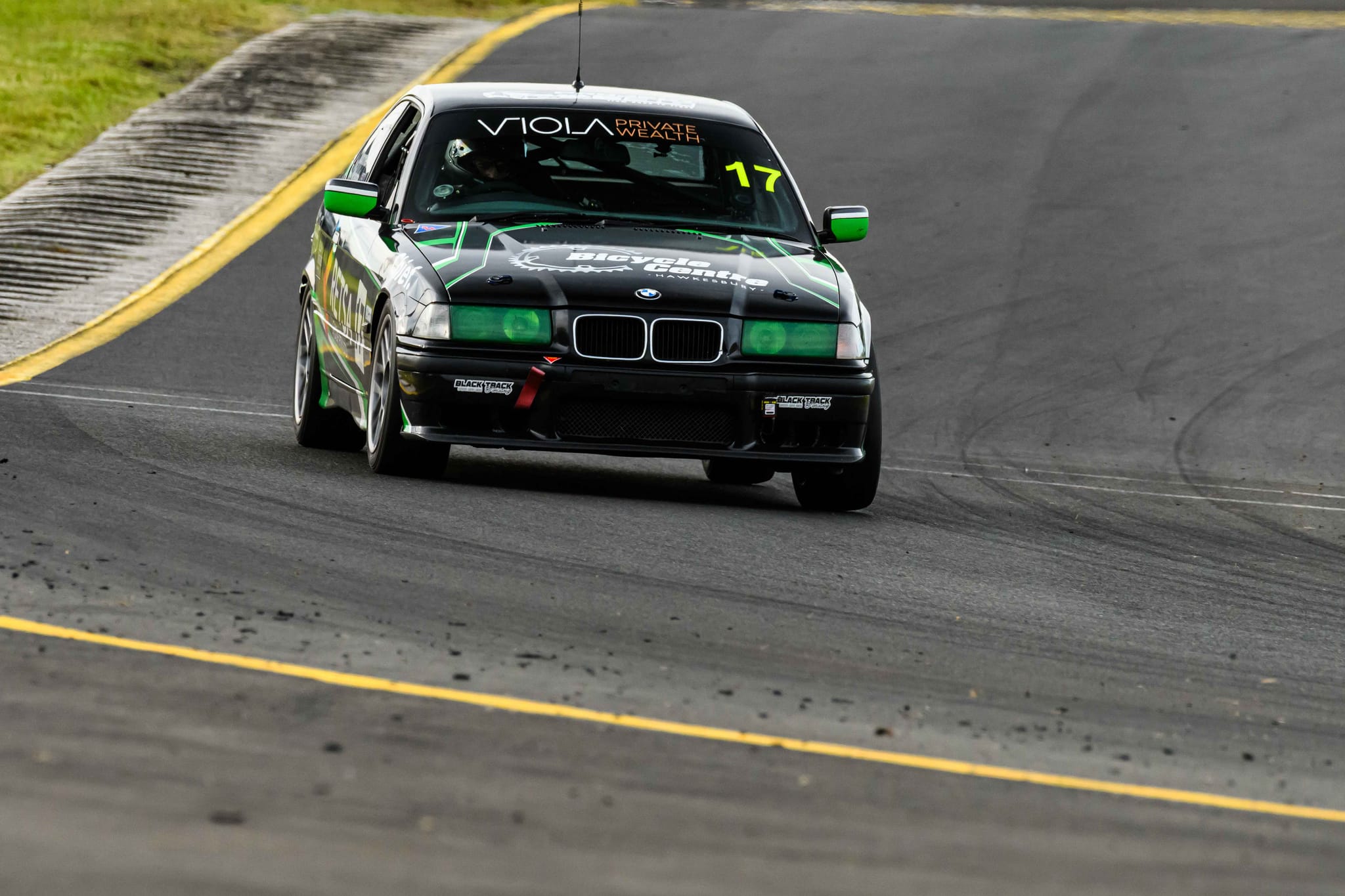Front view of the #17 Project E36 cornering on a damp track at the Sydney 300